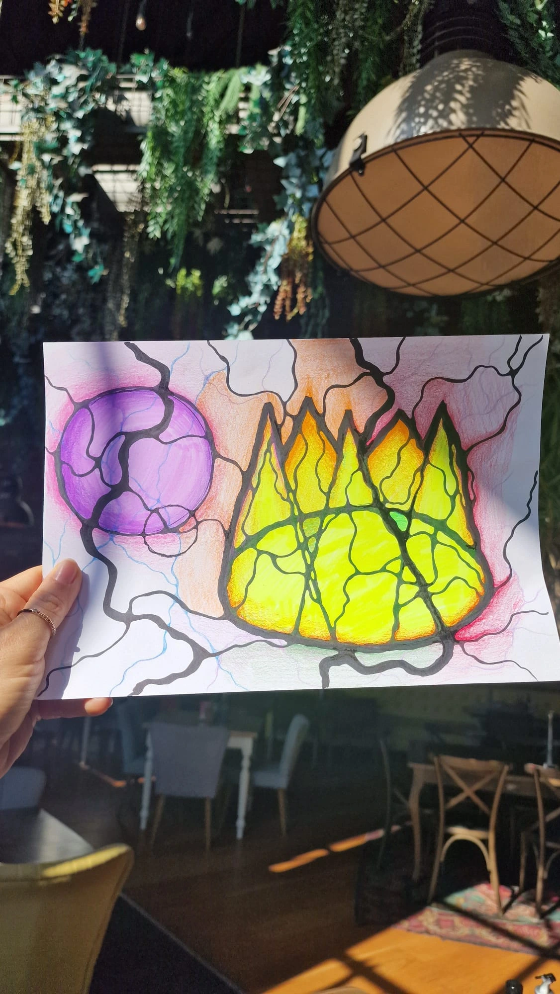 Participant holding a bright crown-themed NeuroGraphica drawing during the I Am a Queen practice